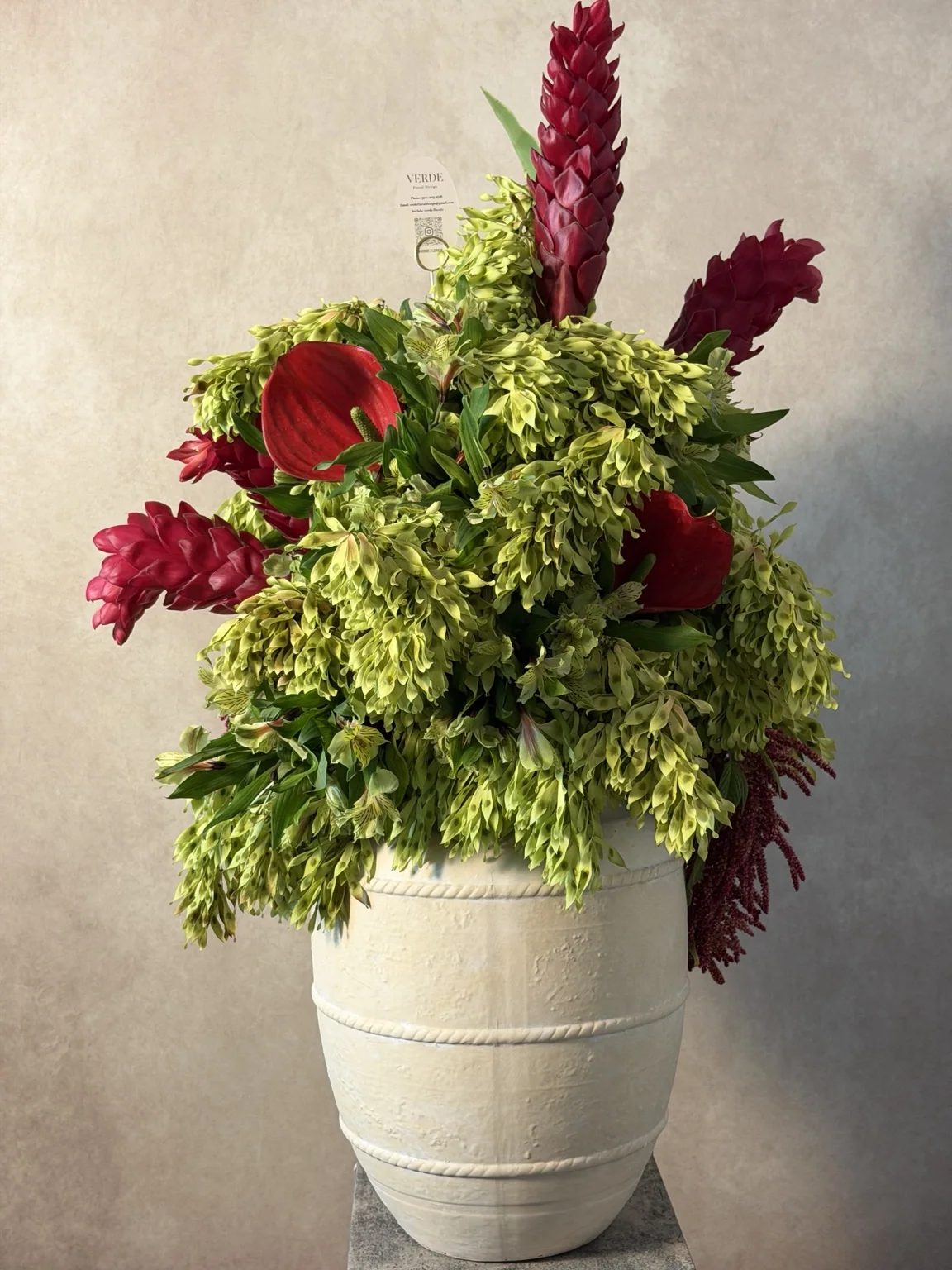 Red ginger, red anthurium and chartreuse greenery in a white ribbed vase