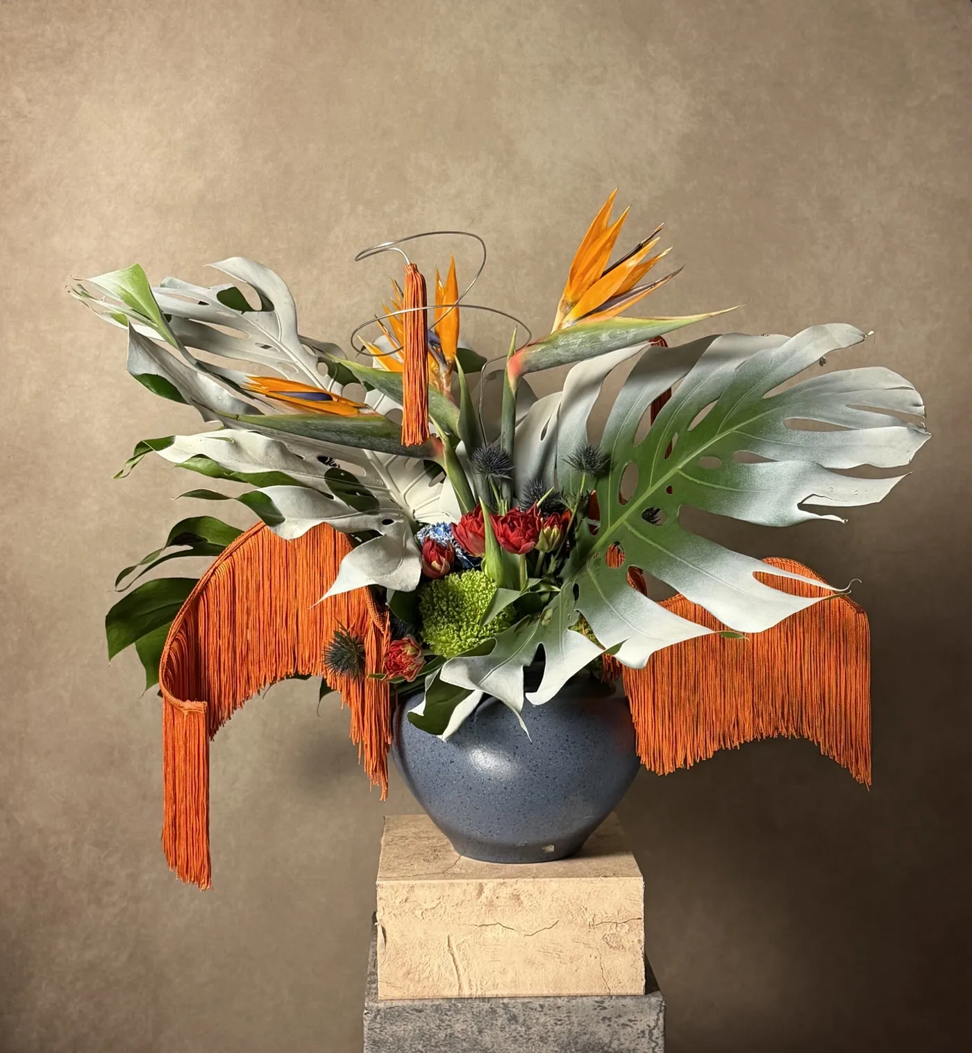 Alternate view of the fashion week sculpture with silvered monstera leaves and cascading orange fringe