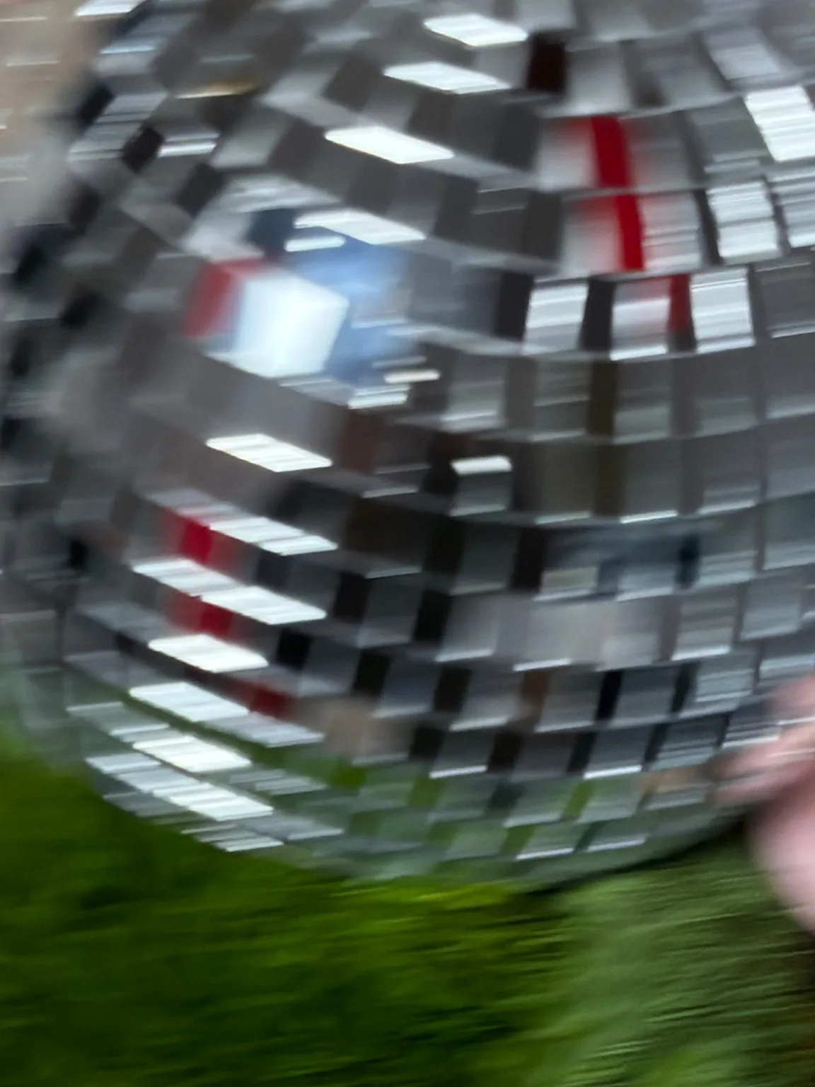 Close detail of a mirror ball resting on green moss