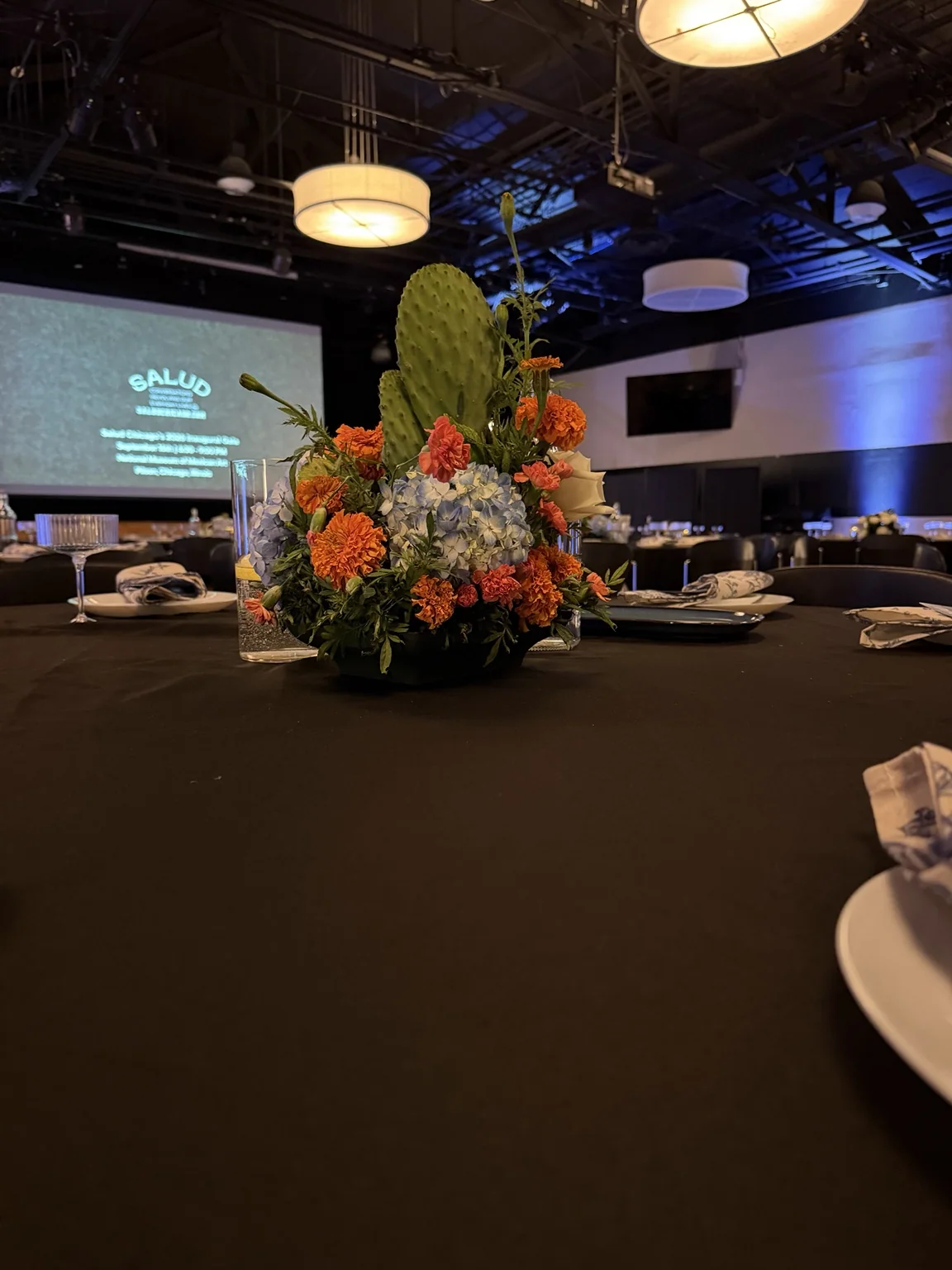 Centerpiece on a table during the event, stage screen behind