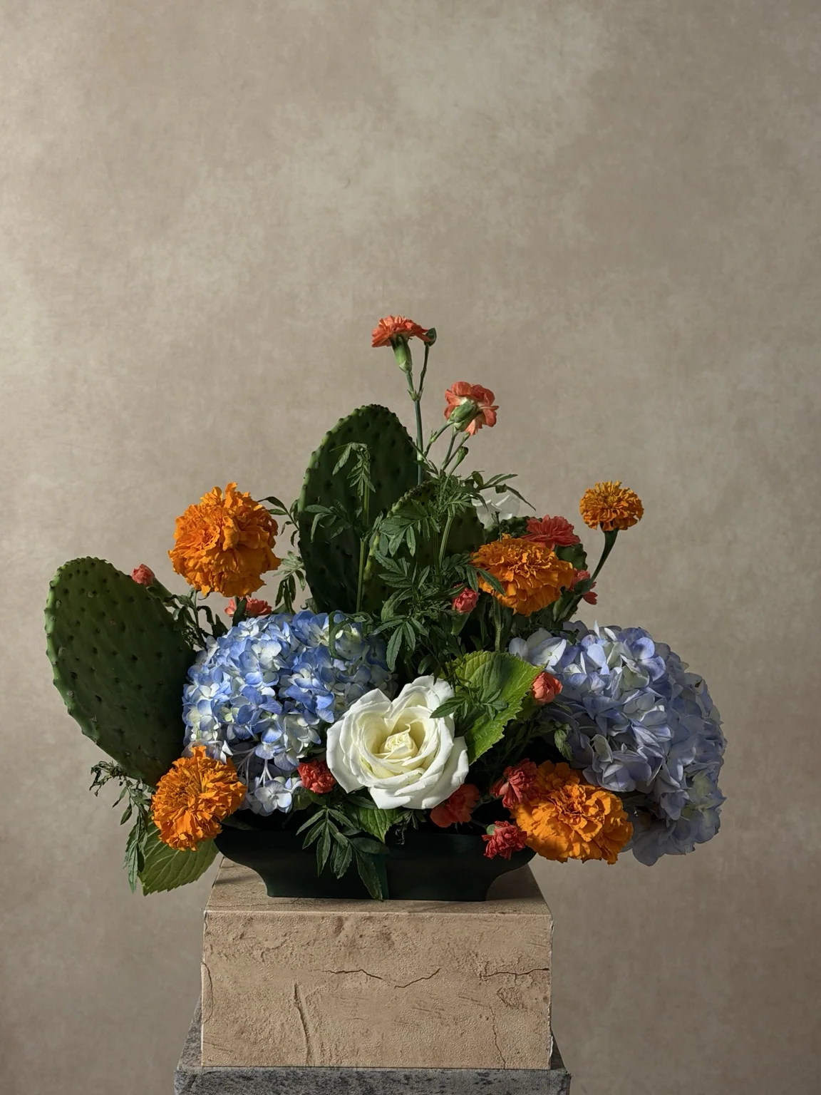 Centerpiece of nopal cactus, marigolds, white roses and blue hydrangea