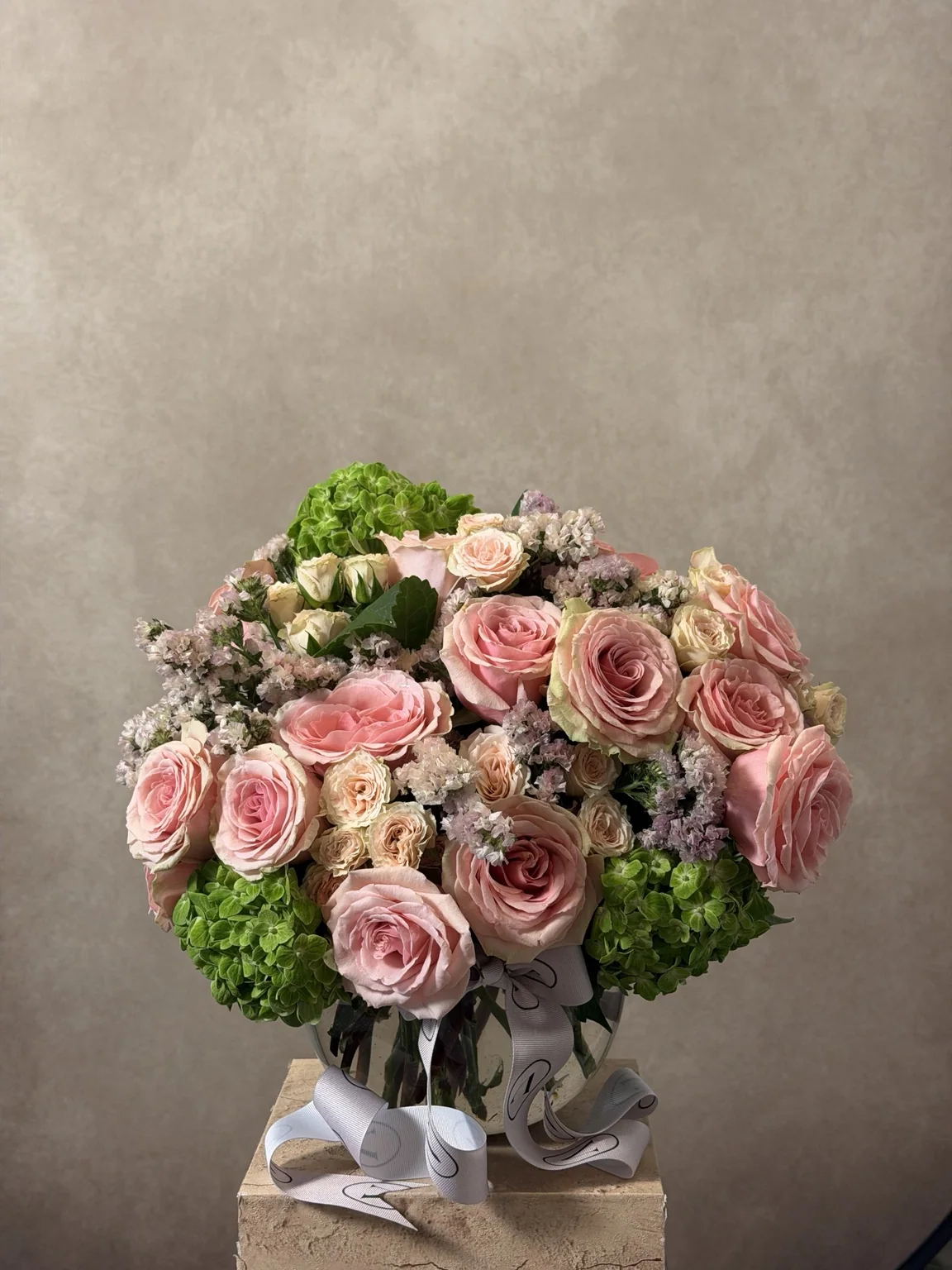Pink roses and green hydrangea in a round arrangement