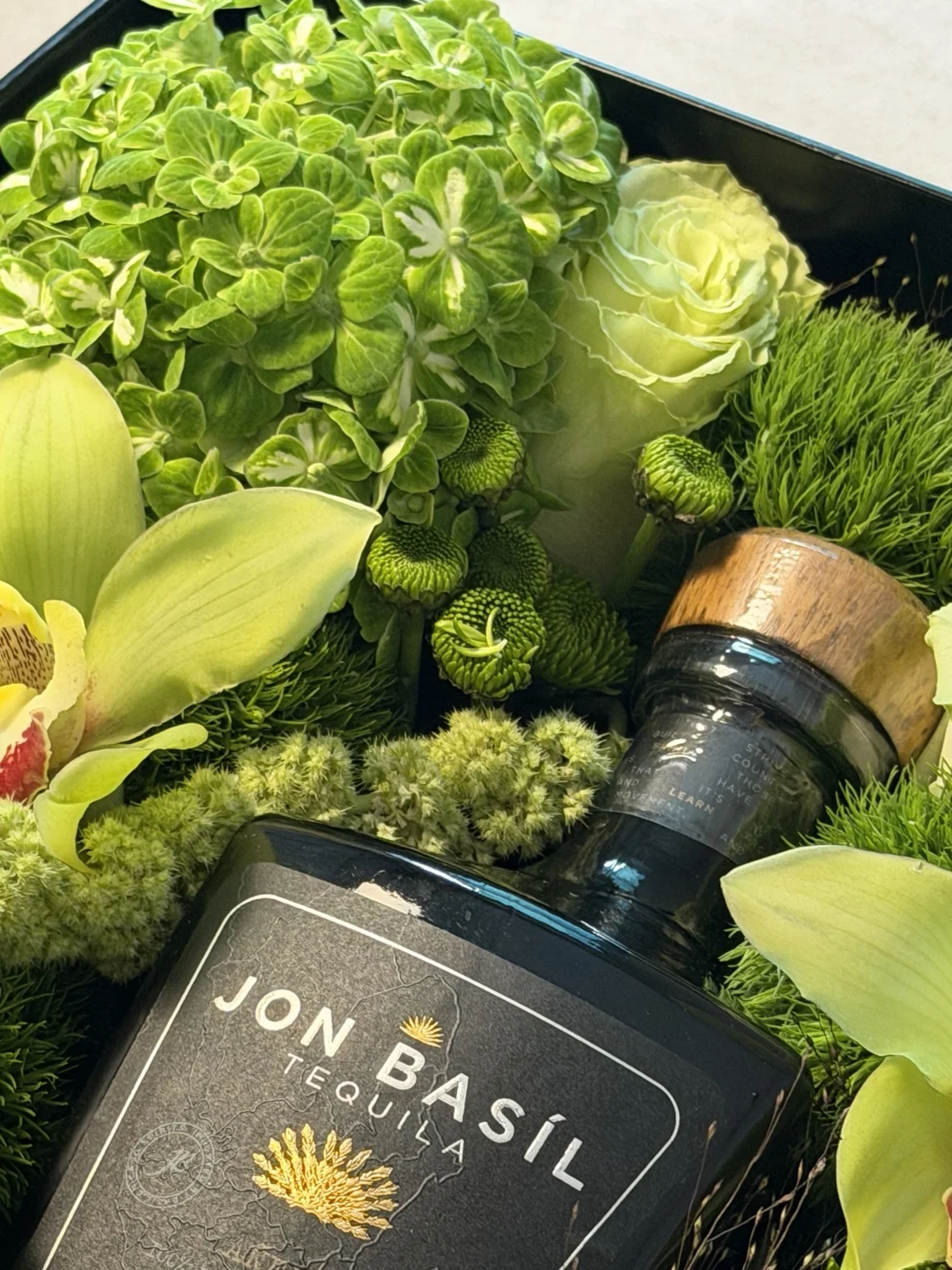 Close detail of green hydrangea and the tequila bottle label